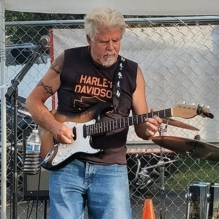 Steve "Buck" Dennison in a Harley-Davidson shirt playing sunburst Stratocaster