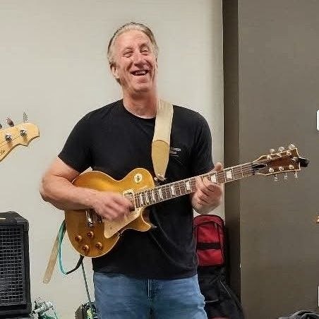Frank Gatto laughing while playing gold-top Les Paul